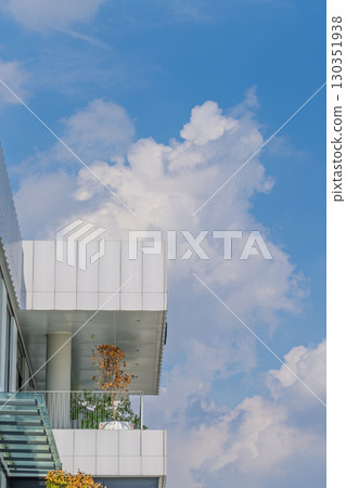 Modern buildings intertwined with blue sky and white clouds Modern buildings intertwined with blue sky and white clouds 130351938
