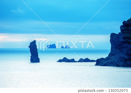 Majestic rock formations near the coast of Iceland during calm twilight hours 130352073