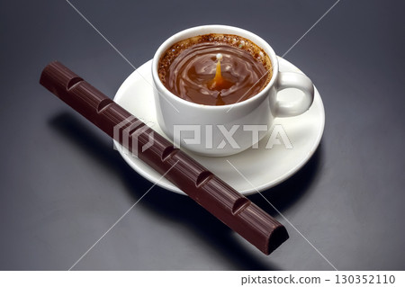 Warm coffee in a white cup with a piece of chocolate on a dark background Warm coffee in a white cup with a piece of chocolate on a dark background 130352110