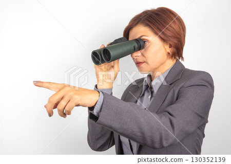 Businesswoman using binoculars to observe distant objects during outdoor expedition Businesswoman using binoculars to observe distant objects during outdoor expedition 130352139