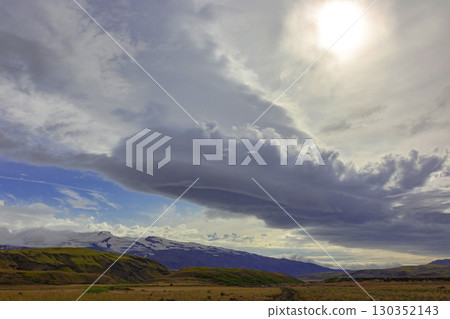 Majestic Icelandic landscape showcasing dramatic clouds over mountains and fields Majestic Icelandic landscape showcasing dramatic clouds over mountains and fields 130352143