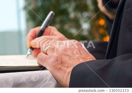Business executive signs important document at formal event in a modern office setting Business executive signs important document at formal event in a modern office setting 130352153