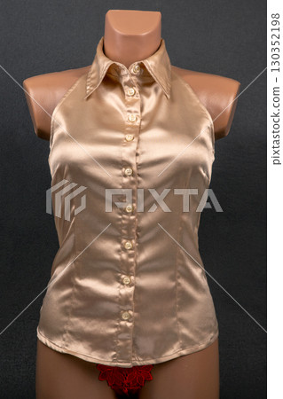 Elegant satin halter neck top showcased on a mannequin against a dark background Elegant satin halter neck top showcased on a mannequin against a dark background 130352198