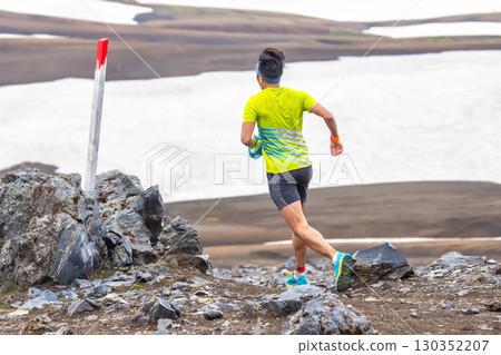 Runner navigating rocky terrain in Iceland's dramatic landscape during summer 130352207