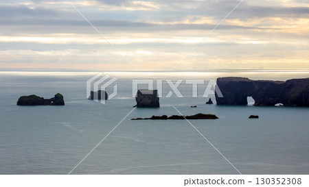 Stunning coastal view of rock formations and cliffs at dusk in Iceland's serene landscape Stunning coastal view of rock formations and cliffs at dusk in Iceland's serene landscape 130352308