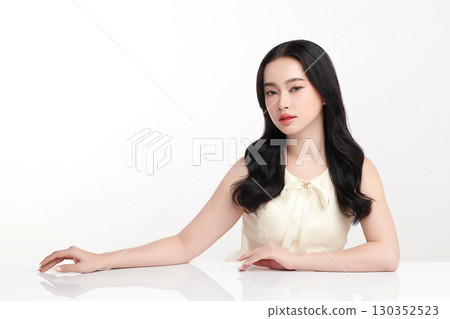 A beautiful young Asian woman with clean, fresh skin against a white background. Skincare, facial treatment, cosmetology, beauty, and spa. An elegant portrait of an Asian woman. 130352523