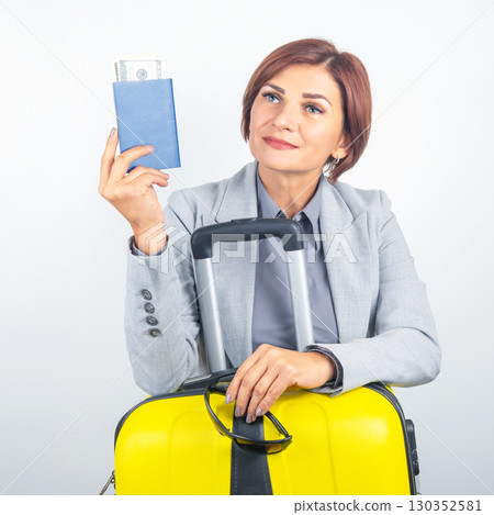 Business traveler holds passport and currency while preparing for departure Business traveler holds passport and currency while preparing for departure 130352581