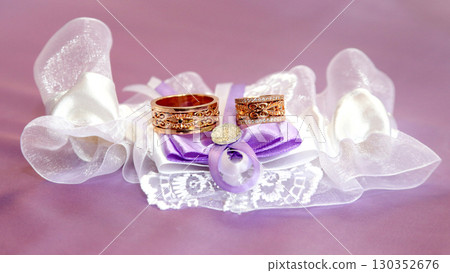Elegant wedding rings placed on a delicate cushion for a romantic ceremony Elegant wedding rings placed on a delicate cushion for a romantic ceremony 130352676