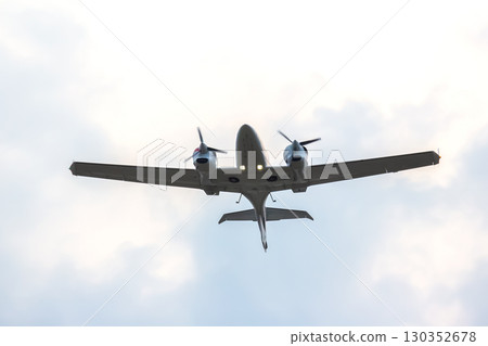 Small aircraft flying overhead against a cloudy sky during a calm day Small aircraft flying overhead against a cloudy sky during a calm day 130352678