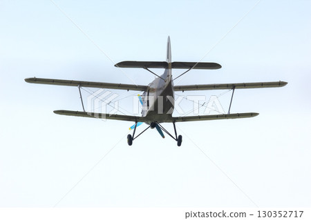 Biplane flying overhead during bright afternoon with clear skies Biplane flying overhead during bright afternoon with clear skies 130352717