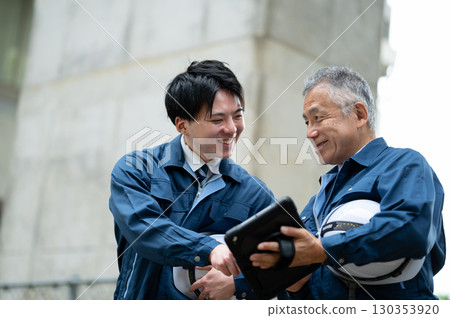 一位年輕且經驗豐富的工程師在建築工地交談 130353920