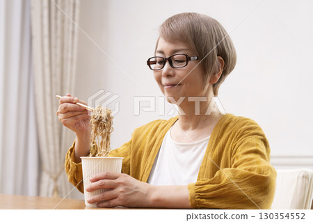 一位老年婦女在餐廳吃泡麵 130354552