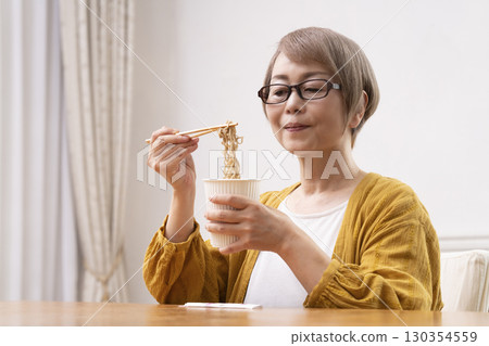 一位老年婦女在餐廳吃泡麵 130354559