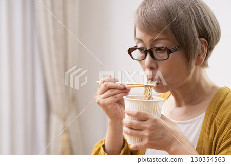 一位老年婦女在餐廳吃泡麵 130354563