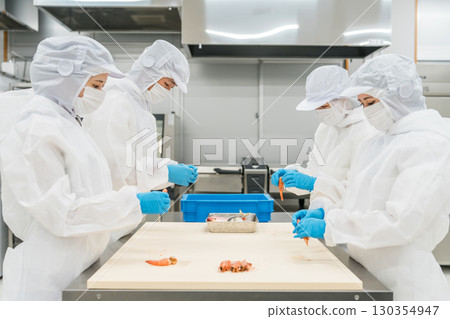 Male and female staff working in food processing wearing sanitary clothing (food hygiene, food factory, hygiene management) Male and female staff working in food processing wearing sanitary clothing (food hygiene, food factory, hygiene management) 130354947