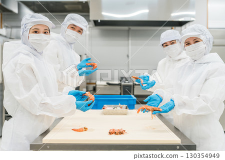 Male and female staff working in food processing wearing sanitary clothing (food hygiene, food factory, hygiene management) 130354949