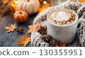 Autumn Morning Warmth: Relaxing in the sunlight with a warm latte and a knitted sweater 130355951