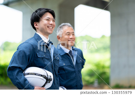 身著工作服的年輕工人和老工人 130355979