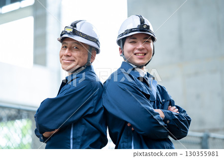 Young and veteran workers in work clothes 130355981