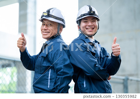 Young and veteran workers in work clothes 130355982