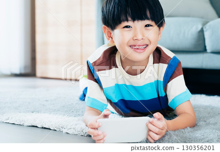 Boy playing with a smartphone 130356201