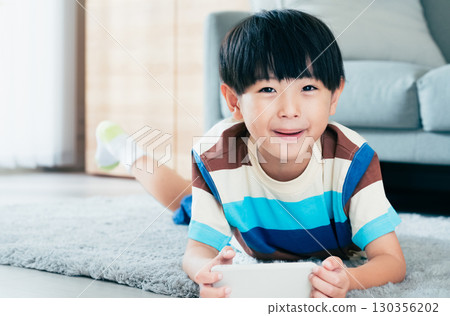 Boy playing with a smartphone 130356202