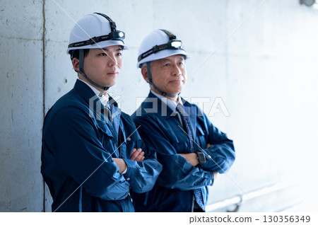 Young and veteran workers in work clothes 130356349