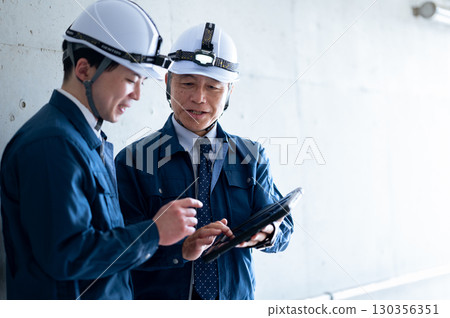 Young and veteran workers in work clothes Young and veteran workers in work clothes 130356351