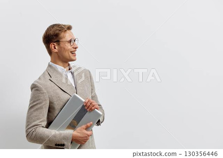 smiling caucasian man holding laptop in beige jacket wear glasses look side isolated on white background digital nomad work concept smiling caucasian man holding laptop in beige jacket wear glasses look side isolated on white background digital nomad work concept 130356446