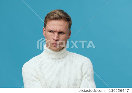 thoughtful man wearing white turtleneck sweater against blue background focused look communication concept thoughtful man wearing white turtleneck sweater against blue background focused look communication concept 130356447