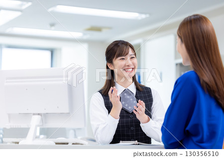 Business woman serving customers at the counter Business woman serving customers at the counter 130356510