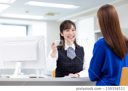 Business woman serving customers at the counter 130356511