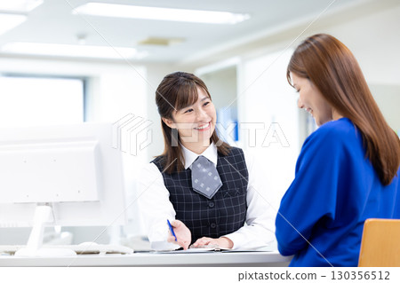 Business woman serving customers at the counter 130356512