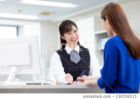 Business woman serving customers at the counter 130356515