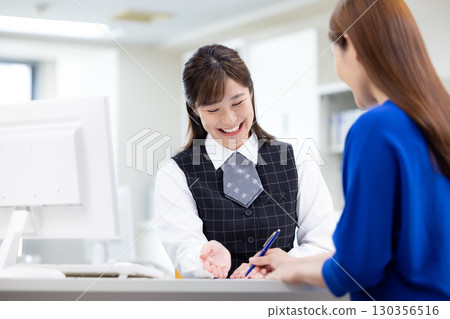 在櫃檯為顧客服務的女商人 在櫃檯為顧客服務的女商人 130356516