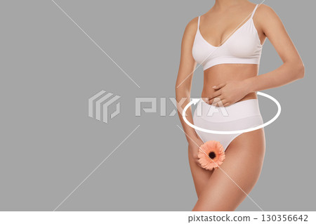 Soft lighting highlights a woman focusing on body care routine 130356642