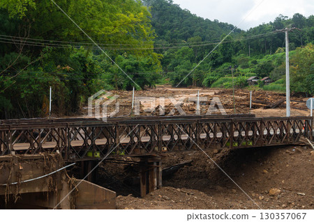 Damaged bridge with debris after flood disaster in rural mountain area Damaged bridge with debris after flood disaster in rural mountain area 130357067