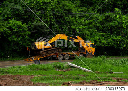 Excavator on Trailer Truck for Flood Recovery and Road Repair Excavator on Trailer Truck for Flood Recovery and Road Repair 130357073