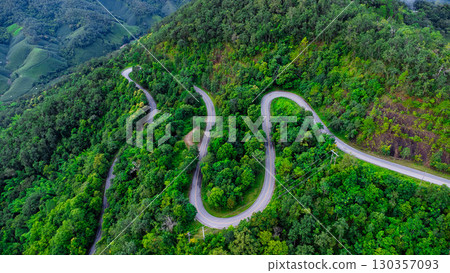 Aerial View of Winding Mountain Road in Green Forest Aerial View of Winding Mountain Road in Green Forest 130357093