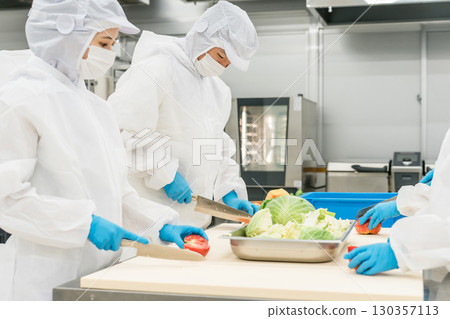 Male and female staff working in food processing wearing sanitary clothing (food hygiene, food factory, hygiene management) 130357113
