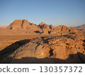Red desert and rocky mountains under a clear blue sky 130357372