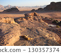 The rocky mountains and desert of Wadi Rum as the shadows gradually grow 130357374