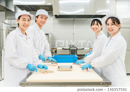 Male and female staff in chef coats preparing chicken (chef, chef, fresh market, food processing) Male and female staff in chef coats preparing chicken (chef, chef, fresh market, food processing) 130357591