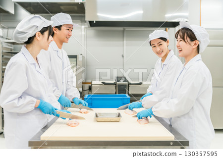 Male and female staff in chef coats preparing chicken (chef, chef, fresh market, food processing) Male and female staff in chef coats preparing chicken (chef, chef, fresh market, food processing) 130357595
