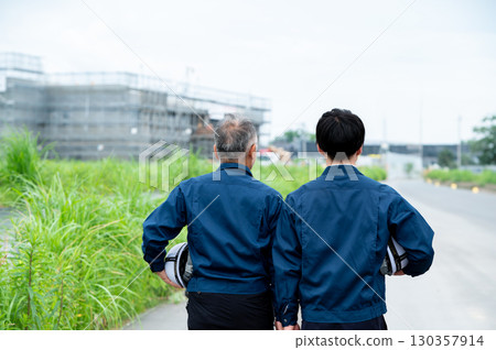 The backs of two people supporting the construction site The backs of two people supporting the construction site 130357914