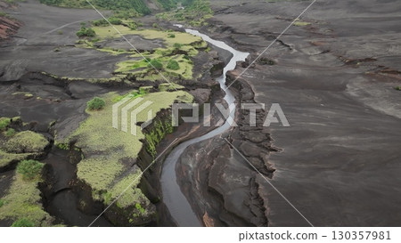 Fiji, Tana Island: Aerial view capturing a river winding through the volcanic landscape of Port Resolution, Tana Island, Fiji, highlighting unique geology and lush vegetation. Drone flight 130357981