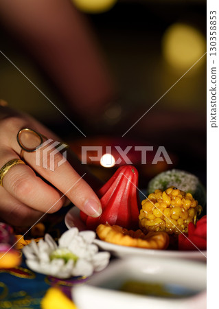 Hand reaching for traditional sweets during Diwali festivities Hand reaching for traditional sweets during Diwali festivities 130358853