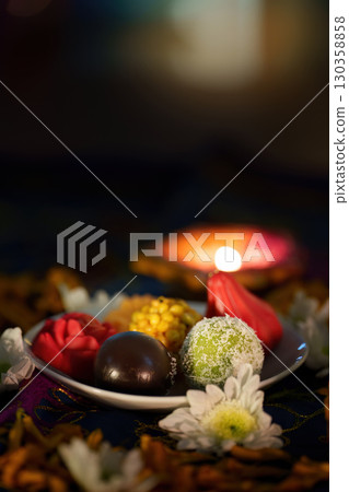 Diwali Celebration: Plate of Sweets and Diyas on Festive Table Diwali Celebration: Plate of Sweets and Diyas on Festive Table 130358858