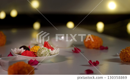 Diwali sweets. A plate of traditional sweets surrounded by marigold flowers and petals. Diwali sweets. A plate of traditional sweets surrounded by marigold flowers and petals. 130358869