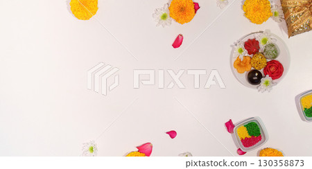 Diwali sweets and flowers scattered on a clean white surface 130358873
